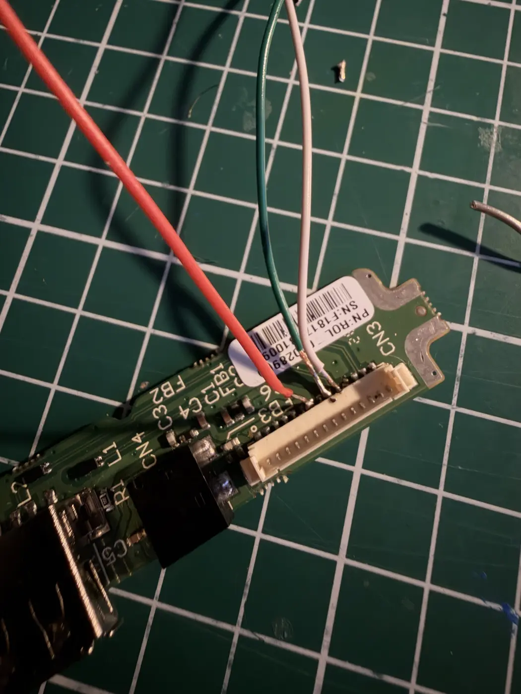 Red, green and white wires soldered to the toes of the CN3 legs before taping