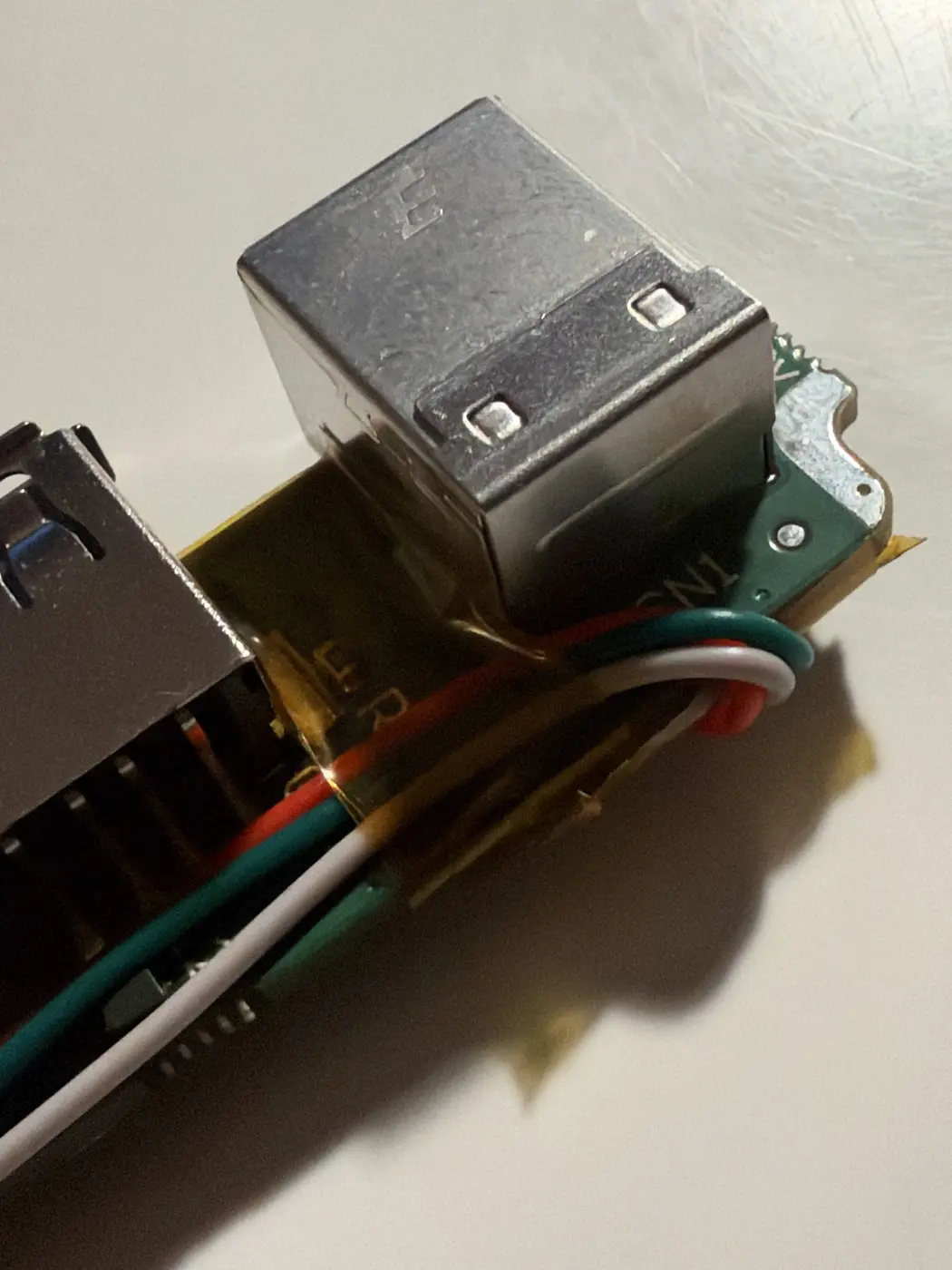 Seaboard RISE ports board with jumper wires wrapped round the board edge past the USB-B jack, taped down with Kapton
